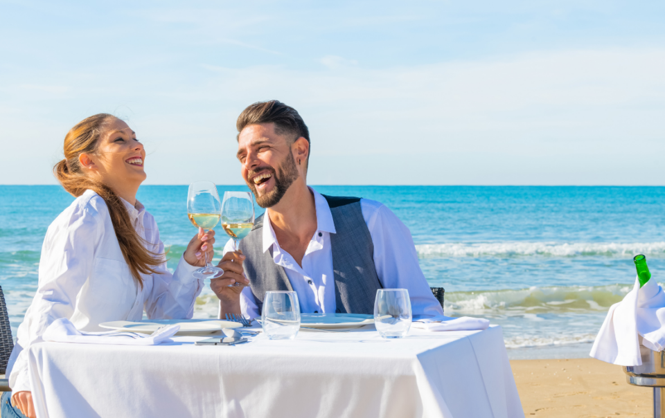 Celebrate. A blissful couple enjoys a romantic beachfront dinner on the picturesque island of Corfu.