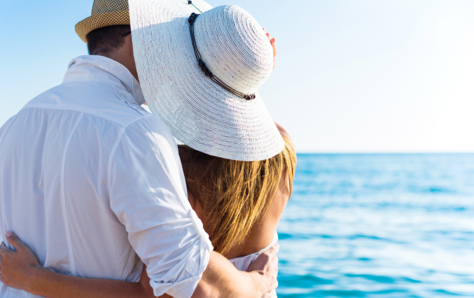 A couple embraces the breathtaking panorama from the terrace of Villa Epavlis, perched on the hills overlooking Komenno Bay in Corfu.